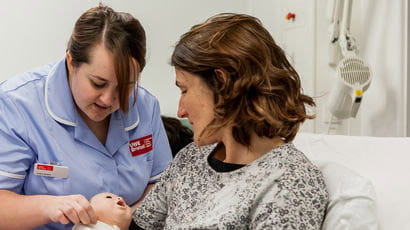 Midwifery student with person role playing the part of a patient.