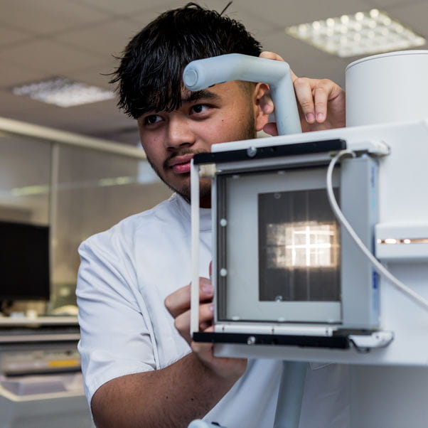 Student using radiography equipment
