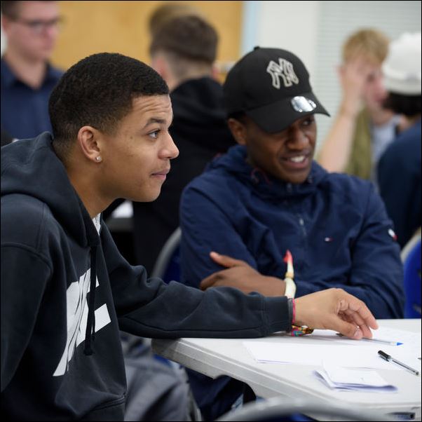 Students sat at chairs writing.