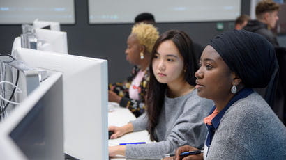 Students working on computers in a study space.