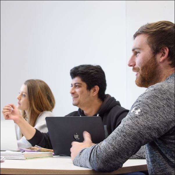 Students using laptops in a study space.