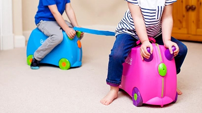 Children riding on Trunki luggage.