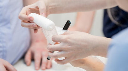 Closeup of healthcare professionals applying a bandage.