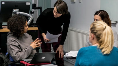 Social Work students talking to a lecturer.