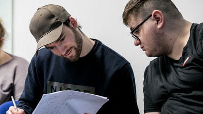 Two students looking at sheets of information.