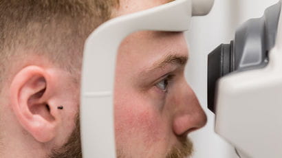 Student using optometry equipment.