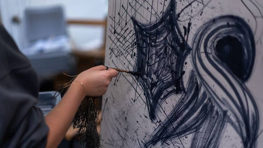 Student painting on canvas as part of Drawing Week event