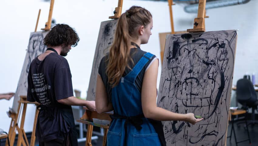 Students painting on canvas with mixed media as part of Drawing Week event