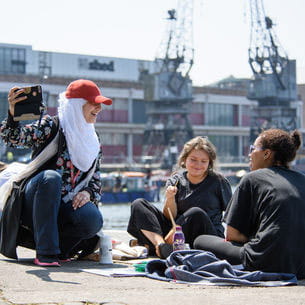 Group of students sitting on the waterfront in Bristol.