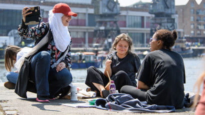 Group of students sitting on Bristol harbourside.
