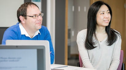 Two smartly dressed people sat at a table.