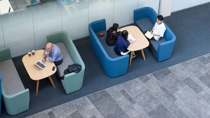 People working in breakout areas of the Bristol Business School.