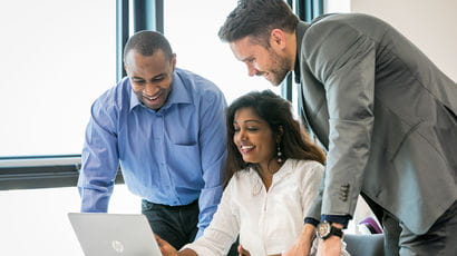 Group of professionals looking at a laptop.