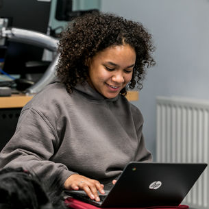 Student working on a laptop in a study room.