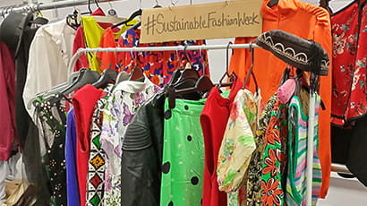 A selection of colourful clothing on a rail.