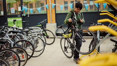 Student putting away his bike in the campus bike shed