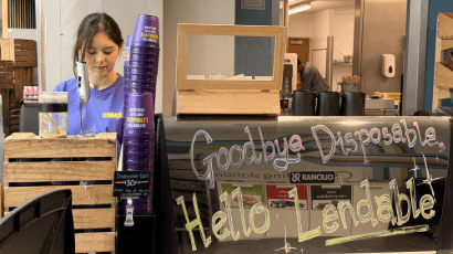 Barista making drinks with Lendable purple cups in X Block.