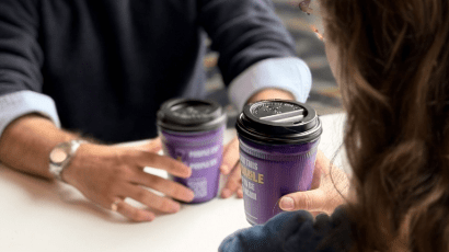 Two students enjoying a hot drink together using Lendable purple cups.