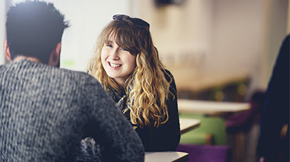 Two people sat chatting across a table