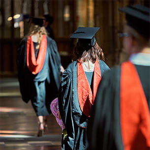 Photo of students walking down an aisle during their graduation ceremony