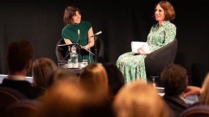 Two people talking on stage at an event.