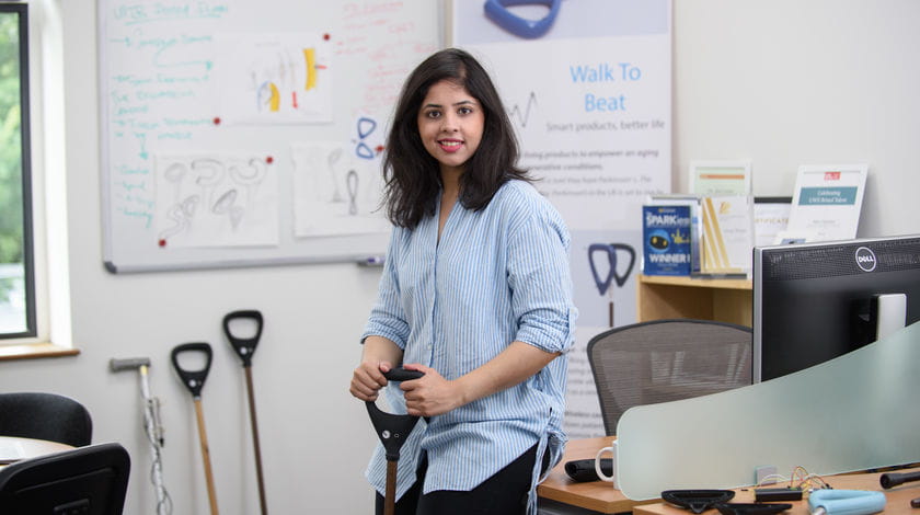 Alumni Neha Chaudhry smiles in a classroom