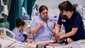 Nursing student learning how to measure a patient's heart rate.