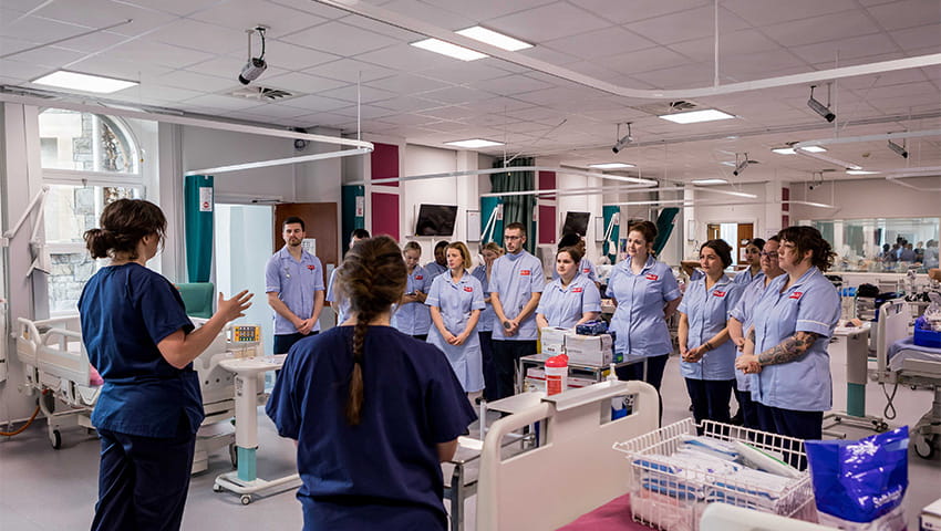 A group of adult nursing students gathering to listen to their programme leaders.