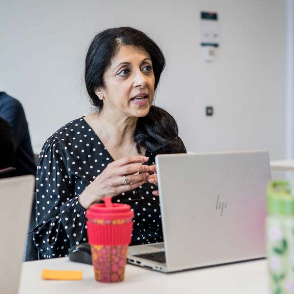 Close up of woman talking with a laptop on the desk.