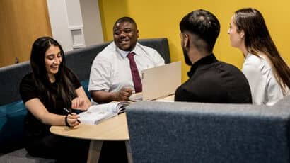 Four students sitting together in an office taking part in an internship.