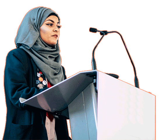 A speaker standing in front of a lectern.