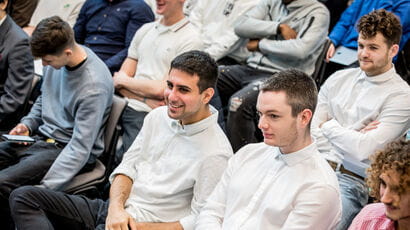 A crowd at an event listening to a talk.