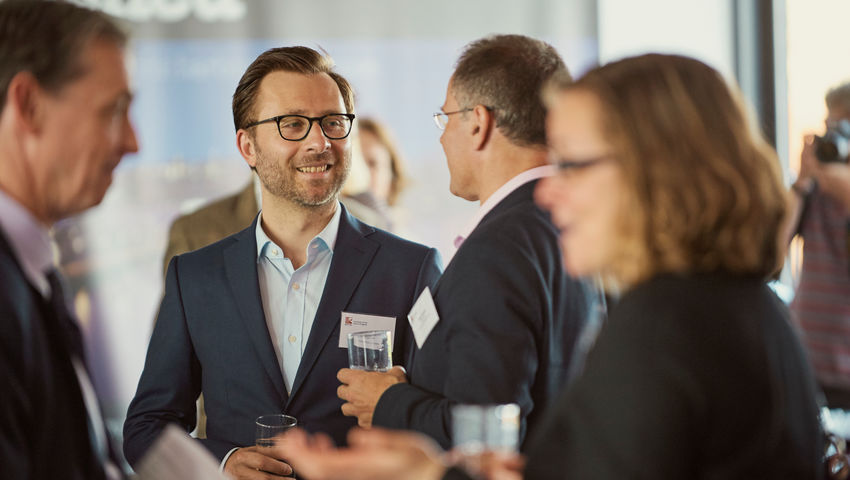 Smartly dressed people at a networking event