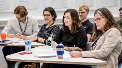 Business partners at an event listening to a talk.
