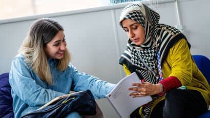 An architecture student chatting to a client about a plan.