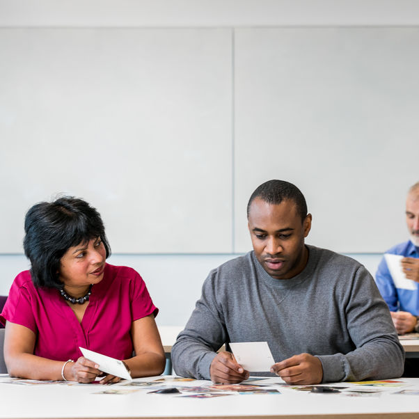 Group of people working around a computer.