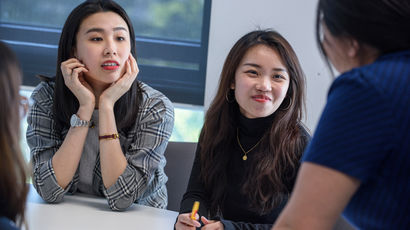 Three Intel placement students sat around a table with a laptop.