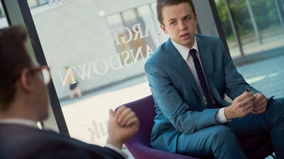 Two placement graduates sat in front of window having a discussion.