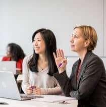 Someone raising their hand to ask a question in a business lecture.