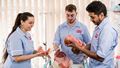 Three UWE Bristol student midwives running through a simulation of delivering a baby.