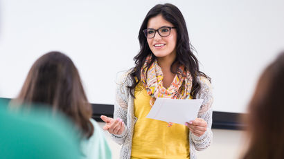 A teacher teaching at the front of a class