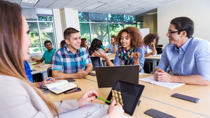 A group of students talking together in a classroom
