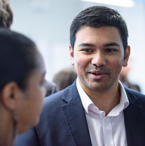 Two smartly dressed people networking at an event.