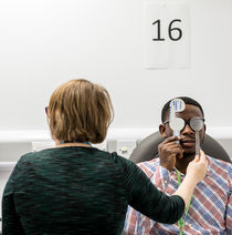 Optometry students using machinery.