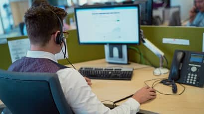 Undergraduate placement student sat at a desk as he looks at a computer screen.