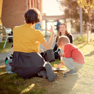 Group of people sitting outside on campus.