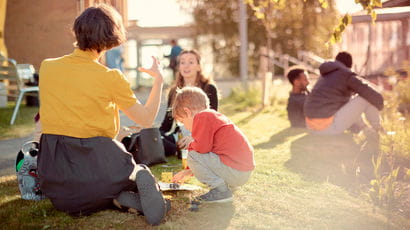 Group of people sitting outside on campus.