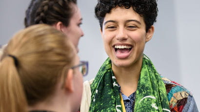 A student laughing with another student