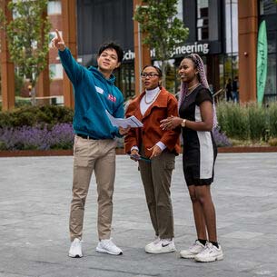 A couple of visitors being directed by a UWE student on campus