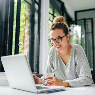Smiling girl looking at a laptop